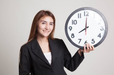 Saati olan genç Asyalı kadın..