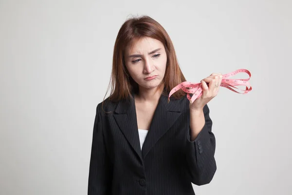 Ongelukkige jonge Aziatische vrouw met meetlint. — Stockfoto