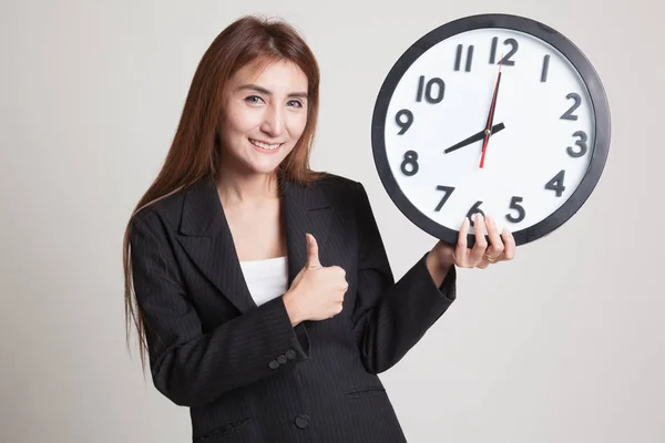 Young Asian woman thumbs up with a clock. — Stock Photo, Image