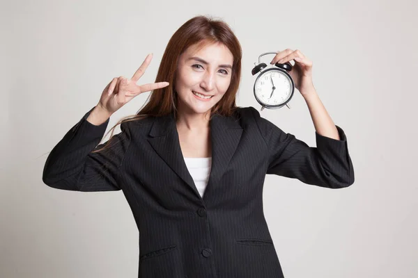 Junge asiatische Geschäftsfrau zeigen Siegeszeichen mit einer Uhr. — Stockfoto