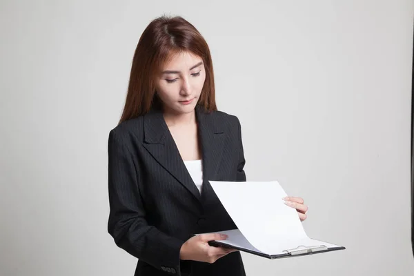 Junge asiatische Geschäftsfrau liest Papier auf Klemmbrett. — Stockfoto