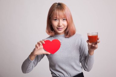 Domates suyu ve kırmızı kalpli genç Asyalı kadın.