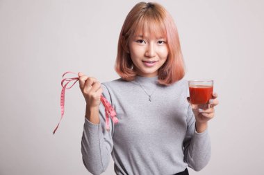 Domates suyu ve ölçüm bandı ile Asyalı kadın.
