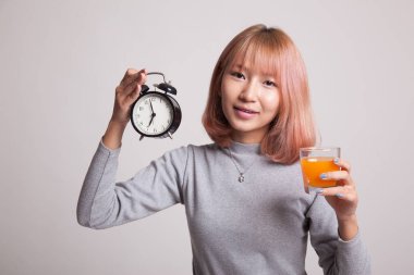 Asyalı kadın saati içki portakal suyu ile.