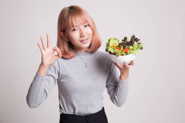 Sağlıklı Asyalı kadın şov Tamam salata ile.