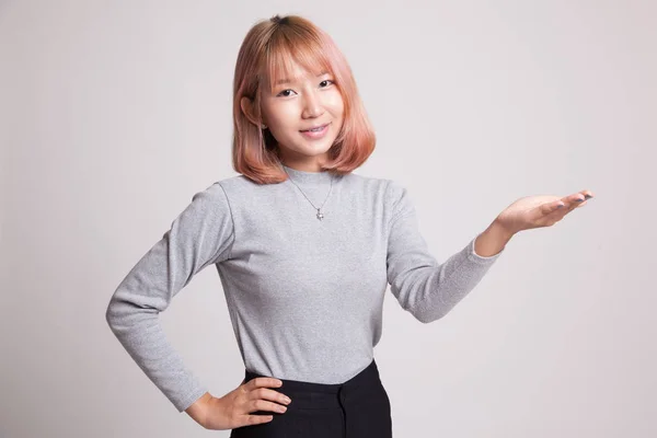 Jonge Aziatische vrouw aanwezig met haar hand. — Stockfoto