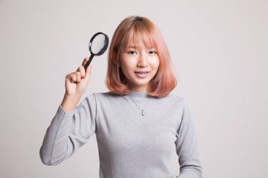 Bir büyüteç ile genç Asyalı kadın.