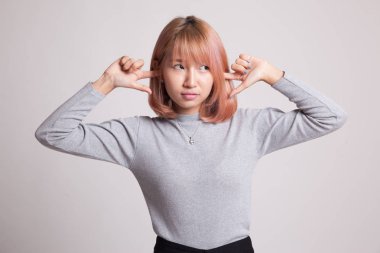 Genç Asyalı kadın parmakları ile her iki kulak engellemek.