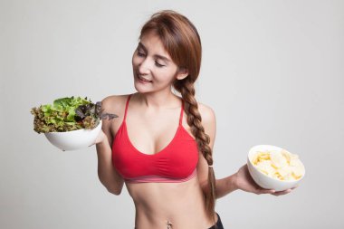 Güzel Asyalı sağlıklı kız salata ve patates cipsi.
