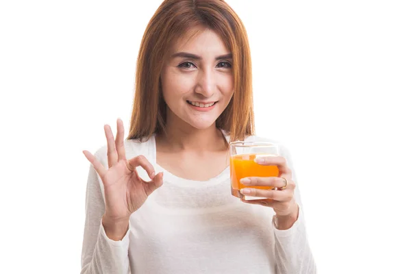 Joven mujer asiática beber jugo de naranja mostrar OK signo . — Foto de Stock