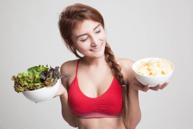 Güzel Asyalı sağlıklı kız salata ve patates cipsi.