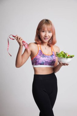 Güzel Asyalı sağlıklı kız ölçme bant ve salata ile.