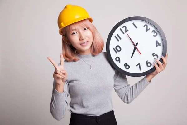 Ingénieur asiatique femme montrent signe de victoire avec une horloge . — Photo