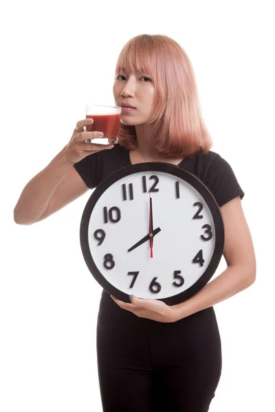 Mladá asijská žena s rajčatovou šťávu a hodiny. — Stock fotografie