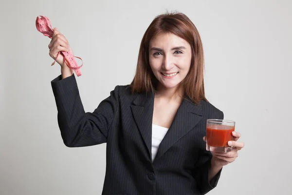 Aziatische vrouw met tomatensap en meten tape. — Stockfoto