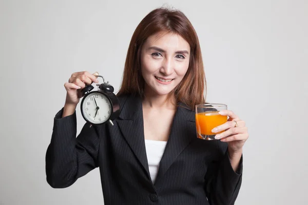 Азіатський жінка з годинником пити апельсиновий сік. — стокове фото