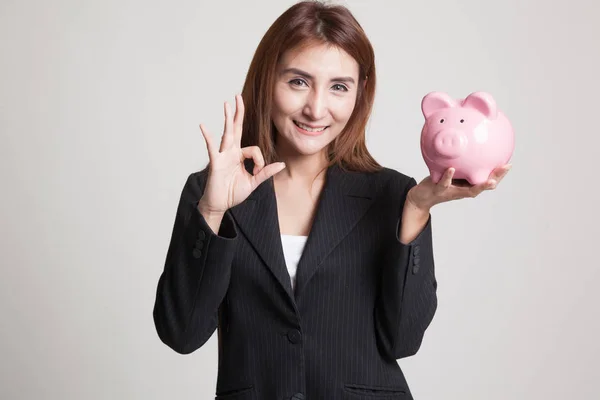 Asian woman show OK  with pig coin bank. — Stock Photo, Image