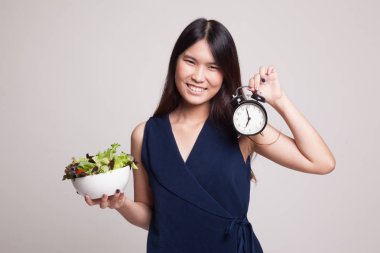 Saat ve salata ile genç Asyalı kadın.