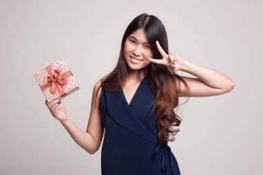 Genç Asyalı kadın göstermek zafer işareti ile bir hediye kutusu.