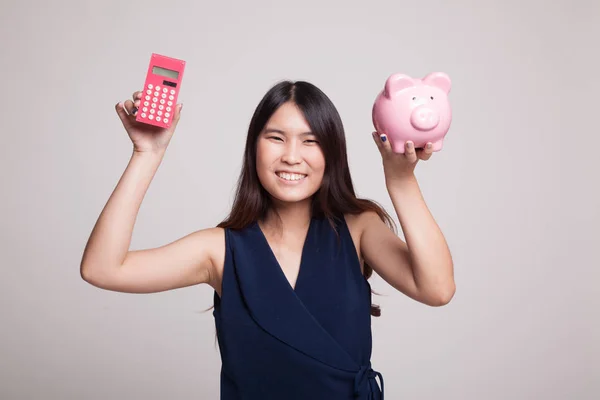 Asian woman with calculator and piggy bank. — Stock Photo, Image