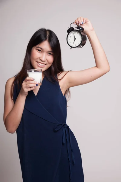 Friska asiatisk kvinna dricksglas mjölk håller klockan. — Stockfoto