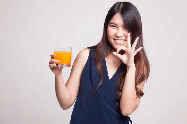 Joven asiática show OK beber jugo de naranja . — Foto de Stock
