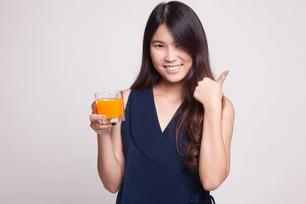 Jovem mulher asiática polegares até beber suco de laranja . — Fotografia de Stock