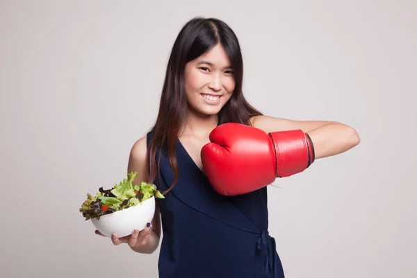 Jovem mulher asiática com luva de boxe e salada . — Fotografia de Stock