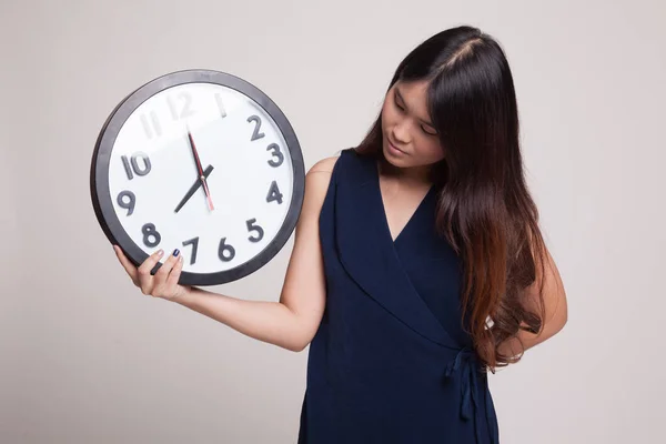 Young Asian woman with a clock. — Stock Photo, Image