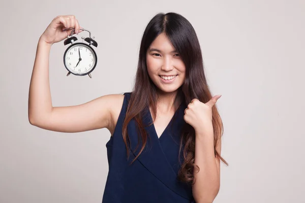 Mladá asijská žena objeví palce s hodinami. — Stock fotografie