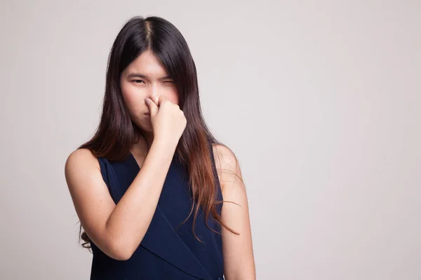 Joven asiática sosteniendo su nariz debido a un mal olor . —  Fotos de Stock