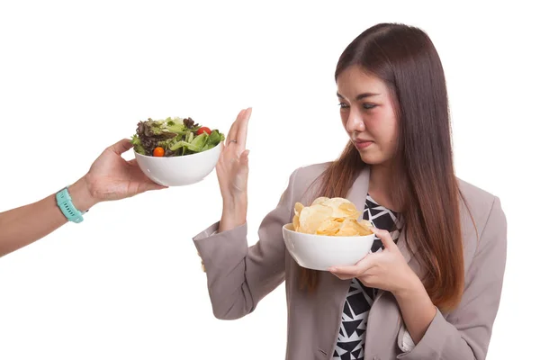 Jonge Aziatische vrouw met aardappel chips nee zeggen tegen salade. — Stockfoto