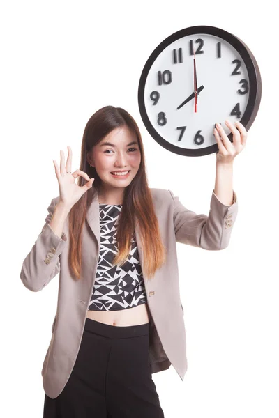 Jeune asiatique femme d'affaires montrer OK avec une horloge . — Photo