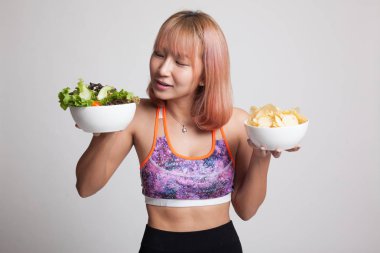 Güzel Asyalı sağlıklı kız salata ve patates cipsi.