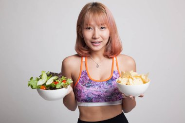 Güzel Asyalı sağlıklı kız salata ve patates cipsi.