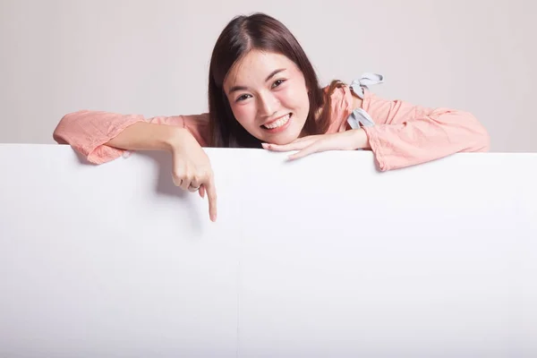 Junge asiatische Frau zeigt auf ein leeres Schild. — Stockfoto