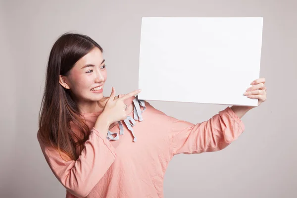 Jonge Aziatische vrouw punt aan leeg teken. — Stockfoto