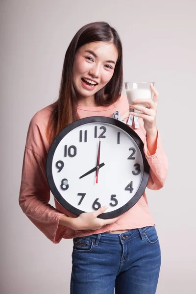 Saludable mujer asiática bebiendo vaso de leche celebrar reloj . — Foto de Stock