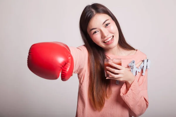 Young Asian woman with tomato juice and boxing glove. — Stock Photo, Image