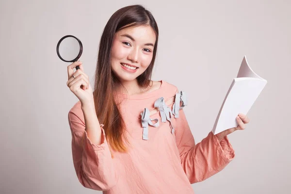 Femme asiatique avec un livre et une loupe . — Photo