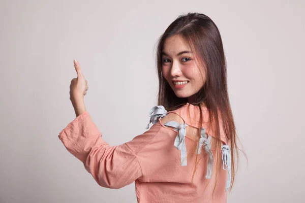 Jonge Aziatische vrouw opdagen terug duimen. — Stockfoto