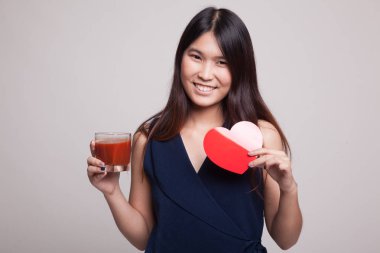 Domates suyu ve kırmızı kalpli genç Asyalı kadın.