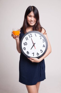 Asyalı kadın saati içki portakal suyu ile.