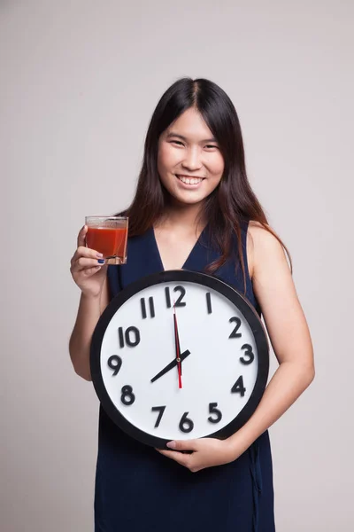 Jeune femme asiatique avec du jus de tomate et horloge . — Photo