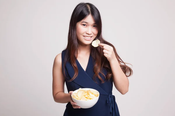 Jovem mulher asiática comer batatas fritas . — Fotografia de Stock