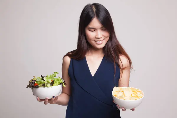 Jovem mulher asiática com batatas fritas e salada . — Fotografia de Stock