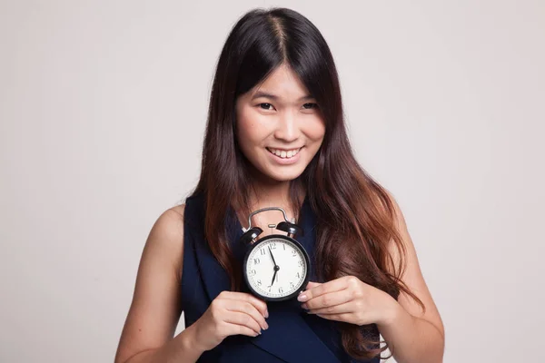 Ung asiatisk kvinna leende med en klocka. — Stockfoto
