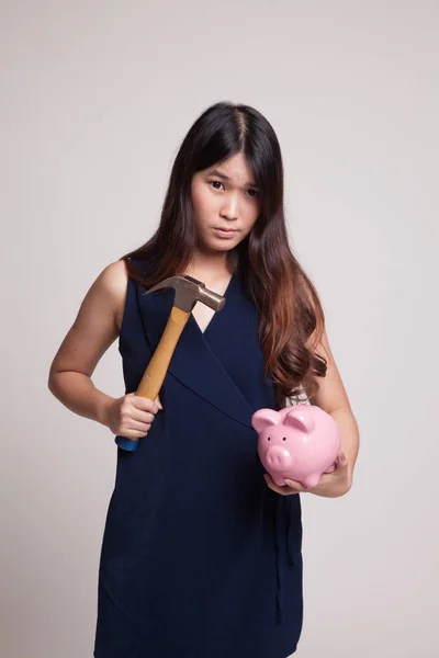 Asian woman with pig coin bank and hammer. — Stock Photo, Image