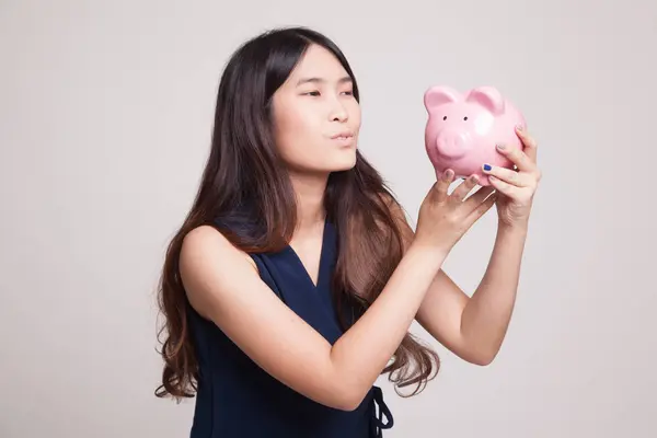 Young Asian woman kiss  a pink coin bank. — Stock Photo, Image