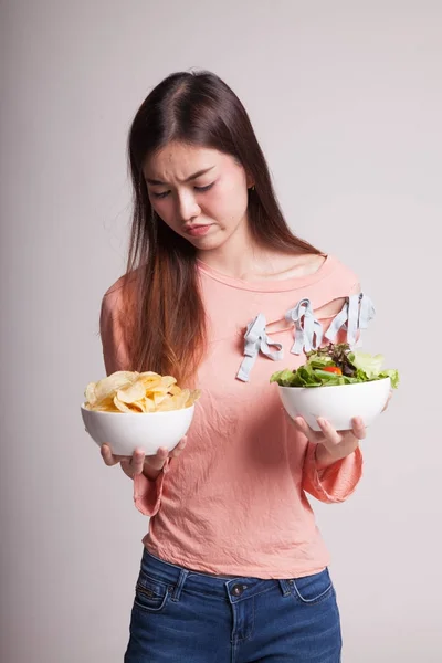 Jonge Aziatische vrouw met aardappel frites en salade. — Stockfoto